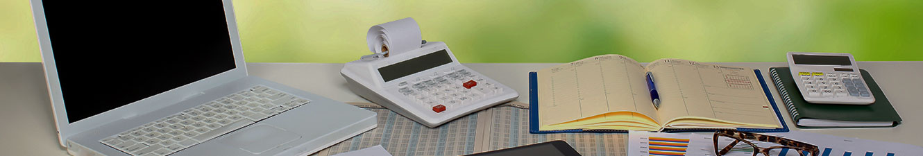 Laptop, calculators, glasses, chart and ledger on a table