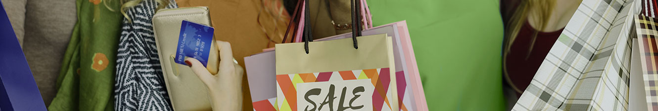 Girl holding a Debit Card and Bags with the word SALE